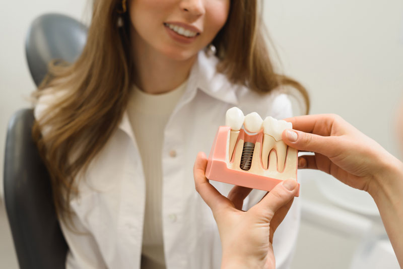 Dental Patient Getting Shown A Dental Implant Model During Her Consultation in Abilene, TX
